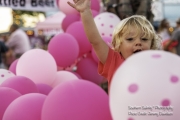 Child playing in pink balloons