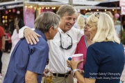 Man with his arms around a man and woman talking